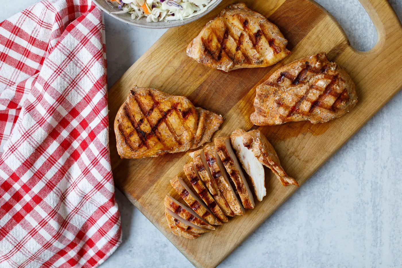 Grilled mesquite chicken breasts sliced on a cutting board
